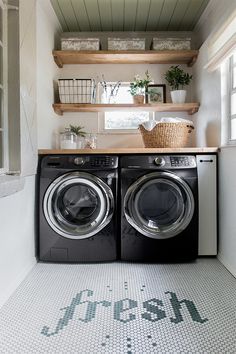 a washer and dryer in a small room with open shelving on the wall