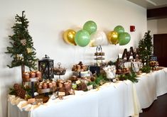 a table topped with lots of different types of food and balloons in the shape of christmas trees