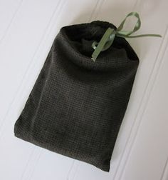 a black bag with a green ribbon hanging from it's side on a white wall