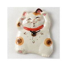 a ceramic clock with a cat design on it's face is shown in white