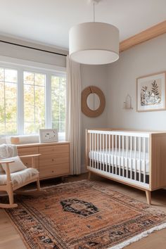 a baby's room with a crib, rocking chair, dresser and window