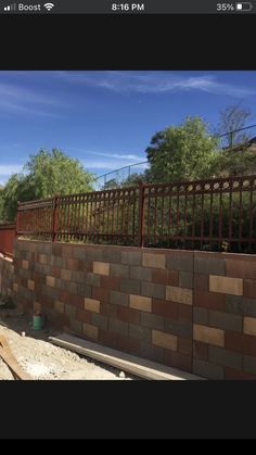 a brick wall with a fence in the background