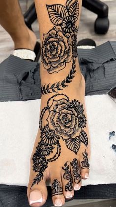 a woman's foot with black and white tattoos on it