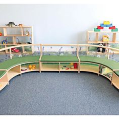 a child's play area with toys and bookshelves on the floor,