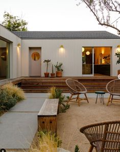 an outdoor patio with chairs, tables and plants