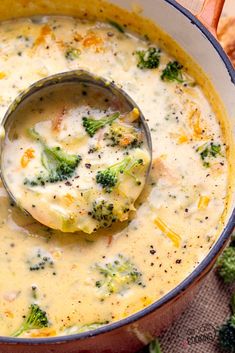 broccoli and cheese soup in a pot with a ladle scooping out