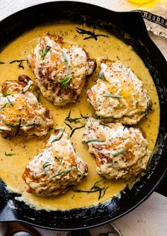 some meat patties are in a skillet with gravy and garnish