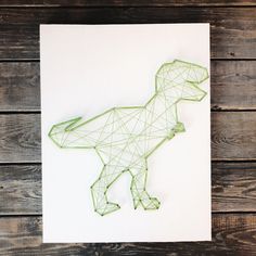 a string art dinosaur on a white paper