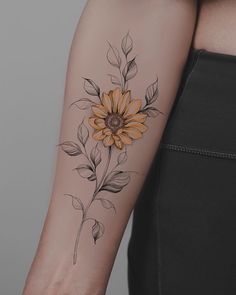 a woman's arm with a sunflower tattoo on it