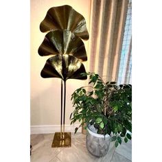 a potted plant sitting on top of a table next to a large metal flower