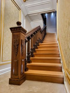 the stairs are made of wood and have intricate carvings on them, along with marble flooring