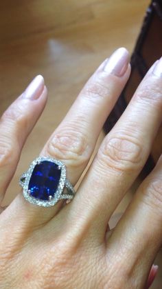 a woman's hand with a ring on it and a blue stone in the middle