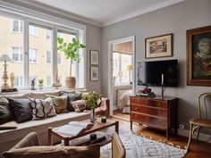 a living room filled with furniture and a flat screen tv mounted to a wall above a window