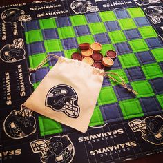 a green and blue blanket with buttons in the shape of a football helmet on it