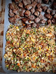 a tray filled with meat and rice next to other food on top of a table