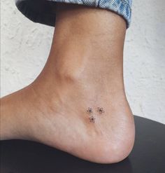 a person's foot with three small flowers on the top and bottom of it