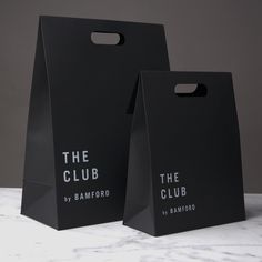 two black paper bags with the club logo on them