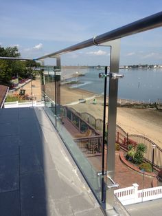 a balcony with glass railing overlooking the beach