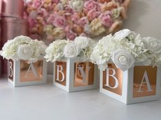 four small boxes with flowers in them on a table