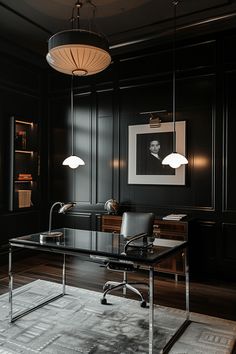 an office with black walls and wooden flooring has a glass desk, two lamps hanging from the ceiling