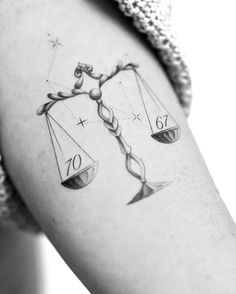 a black and white photo of a lady justice scale tattoo