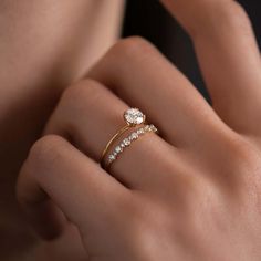 a woman's hand with two diamond rings on her left and the other hand holding an engagement ring