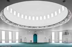 the inside of a large building with blue and white striped flooring, arched windows, and a circular skylight