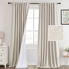 a living room with white furniture and curtains