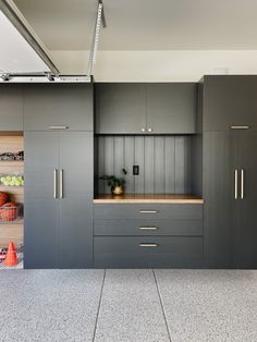 a kitchen with gray cabinets and wooden counter tops on the wall, along with an oven