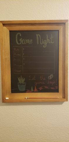 a game night sign hanging on the wall next to a potted succulent