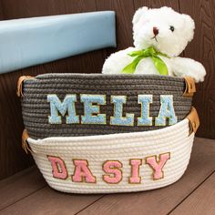 a white teddy bear sitting in a basket that says melia and daisy on it