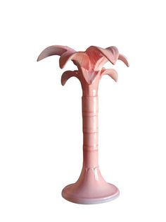 a pink vase with two flowers in it on a white background, that is shaped like a palm tree