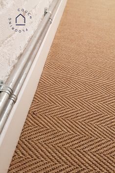 the corner of a room with a carpeted floor next to a wall and metal railing