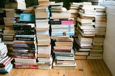 a pile of books sitting on top of a wooden floor