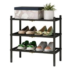 three tiered shoe rack with various pairs of shoes on it and a plant in the middle