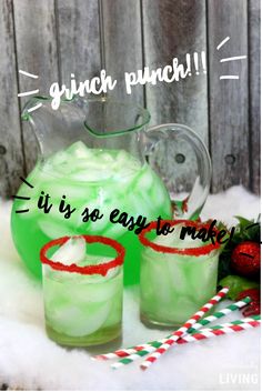 two glasses filled with green liquid sitting next to each other on top of snow covered ground