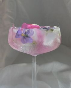 a glass filled with pink and purple flowers