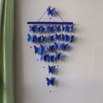 a blue wind chime hanging from the side of a wall