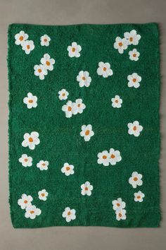 a green rug with white flowers on it