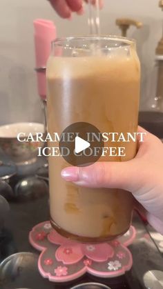 someone is holding a glass with ice coffee in it and the text, caramel instant iced coffee