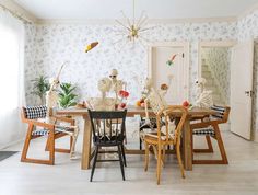 a dining room table with skeleton decorations on it's top and chairs around it