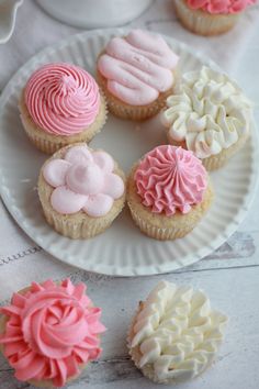 cupcakes with pink and white frosting on a plate