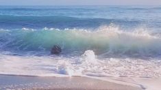 there is a wave coming in to the beach and it looks like they are going into the water