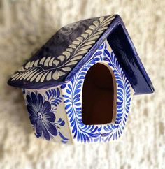 a blue and white birdhouse on the ground