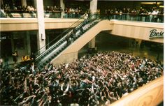 a large group of people standing in front of an escalator