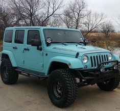 a light blue jeep is parked in the driveway