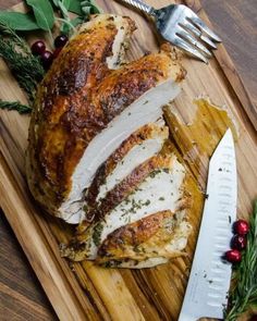 sliced turkey on cutting board with knife and sprig of rosemary next to it