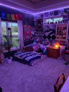 a bedroom with purple lights and pictures on the wall