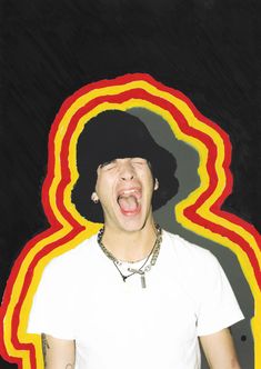 a young man with an afro wig making a silly face in front of a multicolored background