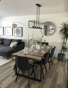 a living room with a couch, dining table and mirror on the wall above it